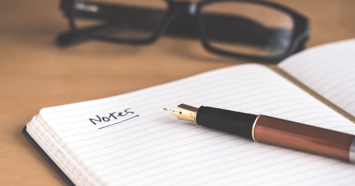 Sabah kahvesinin yanında açık bir defter ve kalem
